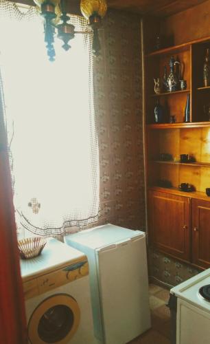a kitchen with a washing machine in front of a window at Colibri Home in Kutaisi