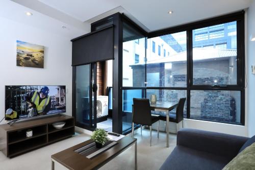 a living room with a couch and a table at Flinders Street Apartments in Melbourne