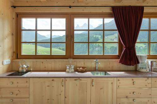 a kitchen with two windows and a counter with a sink at Villa Messner in Funes