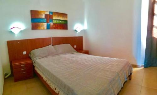 1 dormitorio con 1 cama y 2 luces en la pared en Appartement vue mer et soleil toute l année, en Costa de Antigua