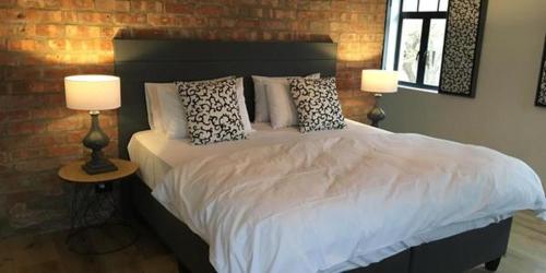 a bedroom with a bed with pillows and two lamps at Hayburg House in Robertson