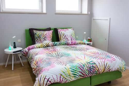 uma cama com um edredão colorido num quarto em Iddup Atrium em Oreye