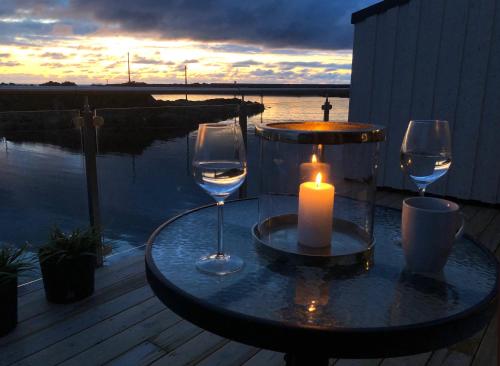 uma mesa com dois copos de vinho e uma vela em Laukvik Suites em Laukvik