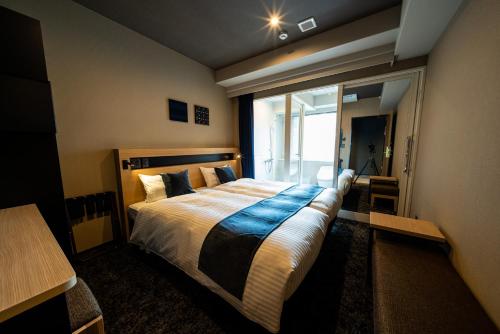 A bed or beds in a room at The Celecton Kurume