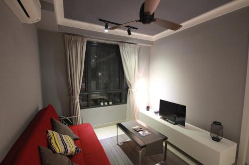 a living room with a red couch and a window at Solstice Service Apartment CYBERJAYA WiFi Netflix KLIA in Cyberjaya