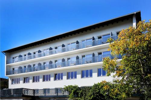 un edificio blanco con balcones. en F Hotel, en Hörsching