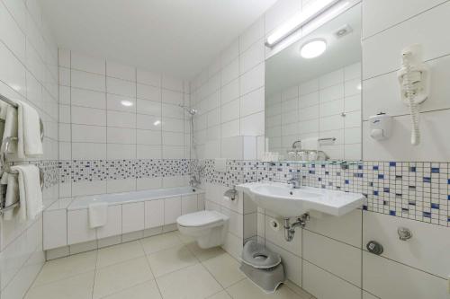 a white bathroom with a sink and a toilet at Medical SPA "Eglės sanatorija" Birštonas in Birštonas