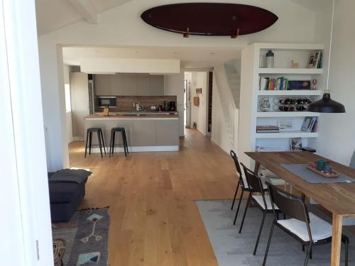 une cuisine et un salon avec une table et des chaises dans l'établissement Maison Eli (charming basque house in Guéthary village), à Guéthary