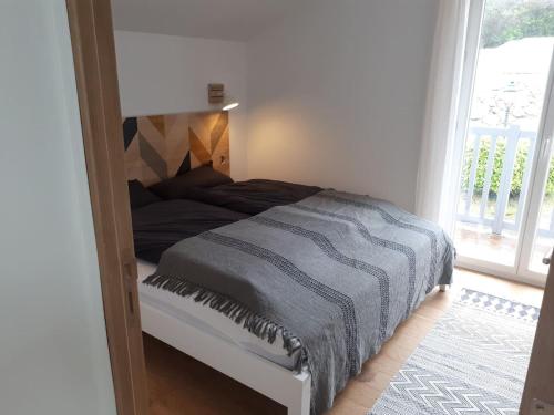 une chambre avec un lit dans une pièce avec une fenêtre dans l'établissement Maison Eli (charming basque house in Guéthary village), à Guéthary