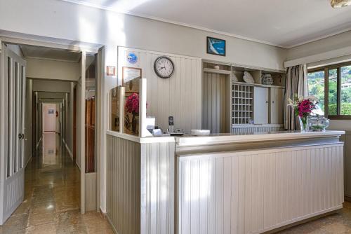 a kitchen with a counter and a clock on the wall at Ionis Hotel in Karavadhos