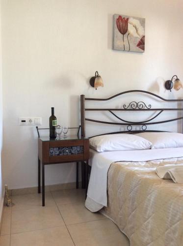 a bedroom with two beds and a table with a bottle of wine at Studios Nopi-Zoi in Skiathos Town