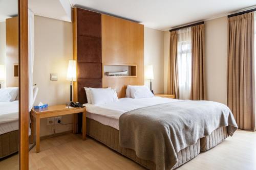 a hotel room with a large bed and a desk at Island Club Hotel & Apartments in Cape Town