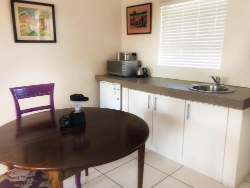 a kitchen with a table and a sink at BlackHorse Accommodation in Stellenbosch