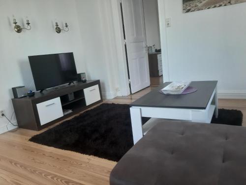 a living room with a table and a tv at FEWO Gerdi und Hanne in Stadt Schenefeld