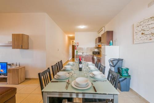 a dining room with a long table with chairs at Seashells 2 Bedroom Apartments with terrace, just off the Bugibba promenade - by Getwaysmalta in St. Paul's Bay