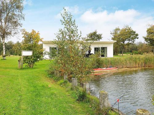 a dog is standing in a house next to a river at 6 person holiday home in Ringk bing in Ringkøbing
