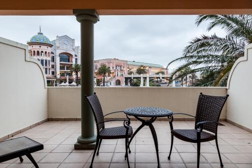 a patio with two chairs and a table on a balcony at Island Club Hotel & Apartments in Cape Town