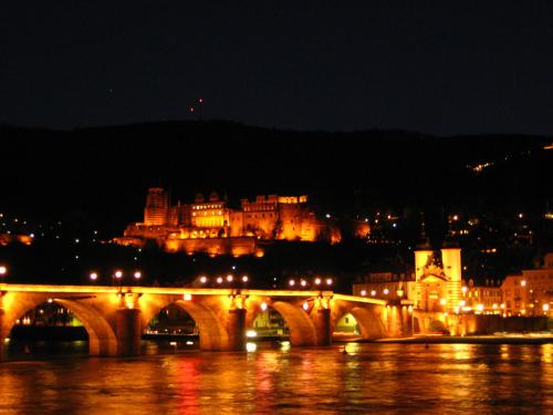 a bridge over a river with a city at night at Neu Heidelberg - Guesthouse & Apartments in Heidelberg