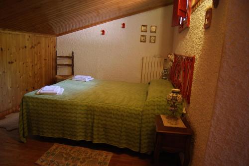 um quarto com uma cama verde e uma mesa em B&B IL QUERCETO em Muro Lucano