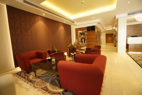 a lobby with red chairs and a table in a building at AZ Hôtels Kouba in Alger