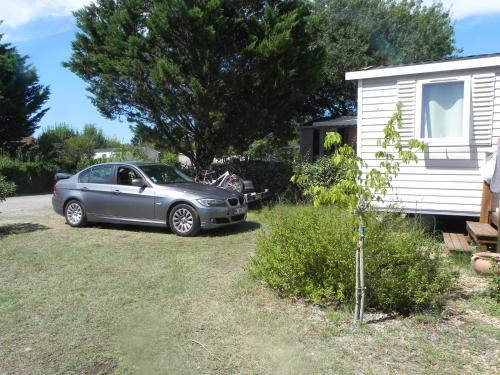 a car parked in a yard next to a house at Mobil Home dans camping Lattes in Lattes