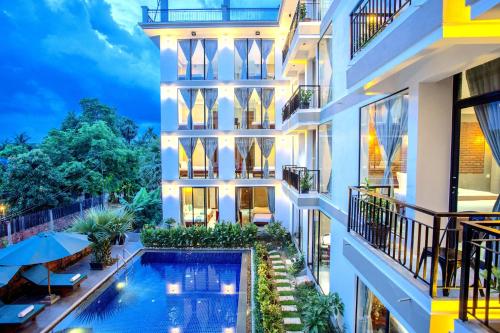 an exterior view of a building with a swimming pool at CENTRAL BLANCHE Residence in Siem Reap