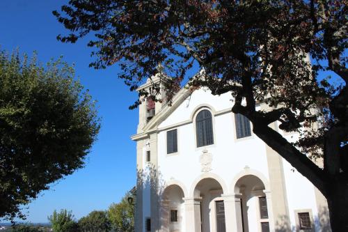 a white building with a tower on top of it at Casa do Castelo Ourém in Ourém