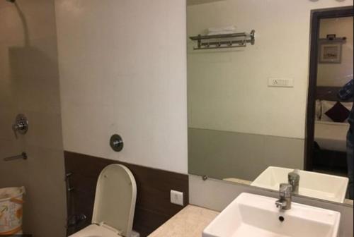 a bathroom with a sink and a toilet and a mirror at Hotel Aditya in Raipur