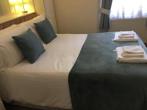 a hotel room with a large bed with towels on it at Bella Vista Hotel in Weston-super-Mare