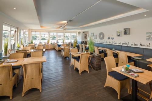a restaurant with wooden tables and chairs and windows at Gästehaus Von Herzen in Lauenburg