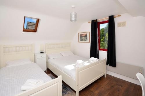 a bedroom with two beds and a window at Cottage 346 - Clifden in Clifden
