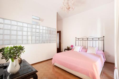 sypialnia z różowym łóżkiem i doniczką w obiekcie Maison Lubeba w Sorrento