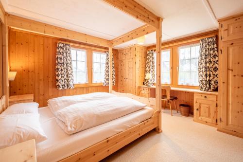 a bedroom with a bed in a room with wooden walls at Chalet Cauma in Flims