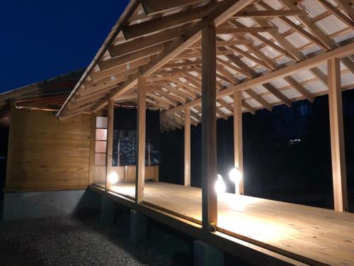 a wooden pergola with lights on it at night at yuzaka - natural & sustainable inn - in Kazuno