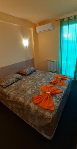 a bedroom with two beds with orange bows on them at Семеен хотел Къща Тодорови in Stara Zagora
