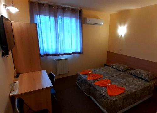 a room with two beds with orange bows on them at Семеен хотел Къща Тодорови in Stara Zagora