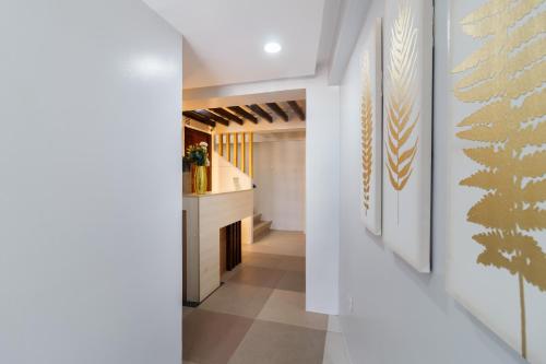 a hallway with white walls and art on the walls at Amazi Homestay-Dumaguete in Dumaguete