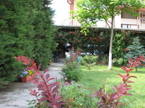 a garden with flowers and plants in front of a building at Семеен хотел Къща Тодорови in Stara Zagora