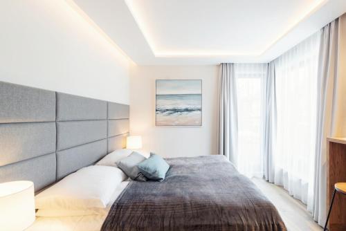 Un pat sau paturi într-o cameră la Meridian Luxury Apartments by Grand Apartments