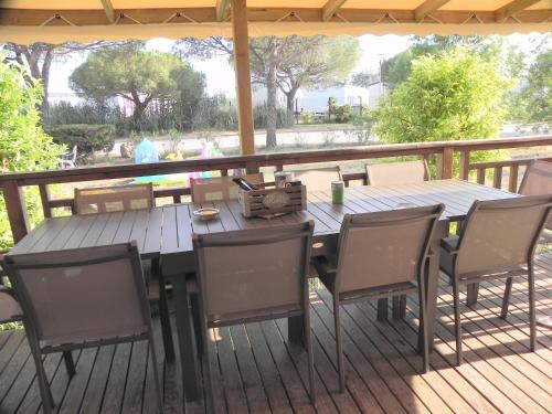 une table et des chaises en bois sur une terrasse dans l'établissement Mobil Home dans camping Lattes, à Lattes