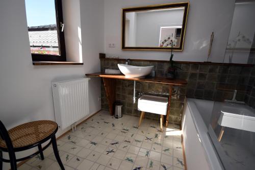 a bathroom with a sink and a mirror and a chair at Marktplatz Mountain View in Gmunden