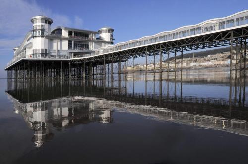 a pier with a building on top of the water at Bella Vista Hotel in Weston-super-Mare