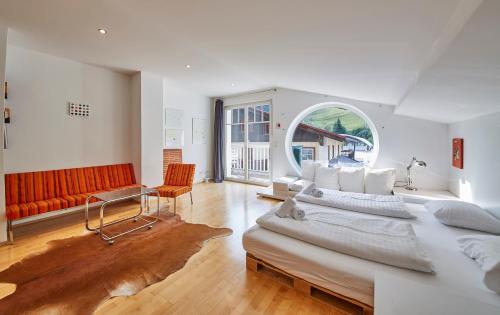 a living room with a large bed and a couch at Casa Vita Apartments in Saalbach Hinterglemm