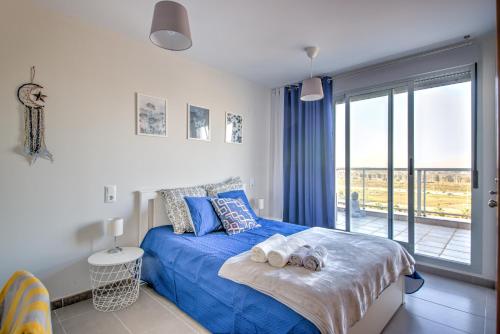 a bedroom with a blue bed and a balcony at Apartment BlueHat Moncofa in Moncófar
