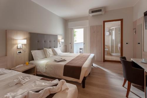 Habitación de hotel con 2 camas y baño en Hotel Montereale, en Pordenone