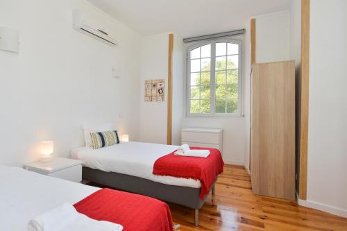 una camera da letto con due letti e una finestra di Oeiras 2 - Checkinhome a Oeiras