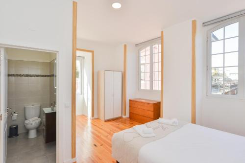 una camera da letto bianca con un letto e un bagno di Oeiras 2 - Checkinhome a Oeiras