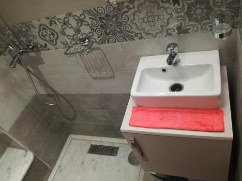 a bathroom with a white sink and a red towel at Genova surf house in Imsouane