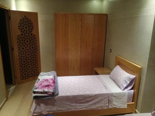 a bedroom with a bed and a wooden cabinet at Genova surf house in Imsouane