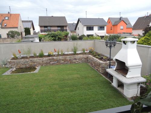 a garden with a bench and a stone wall at Ferienwohnung Steffi in Andernach